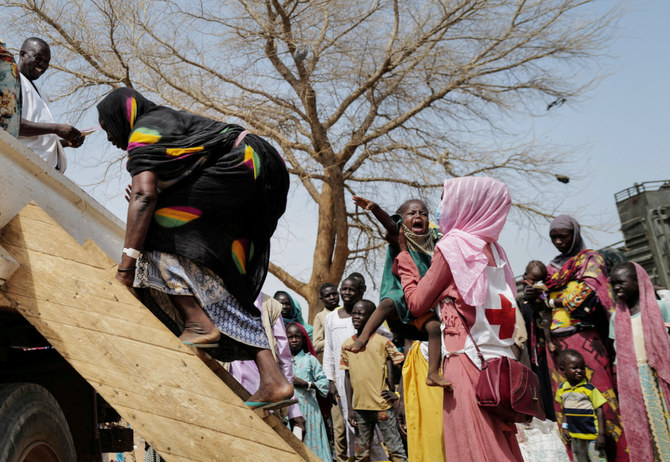 A Red Cross worker holds a child while his mother, a Sudanese woman who fled the conflict in Geneina in Sudan's Darfur region, climbs on a truck that will relocate them from a school where they were temporarily accommodated to a refugee camp, in Adre, Chad July 23, 2023. (REUTERS)