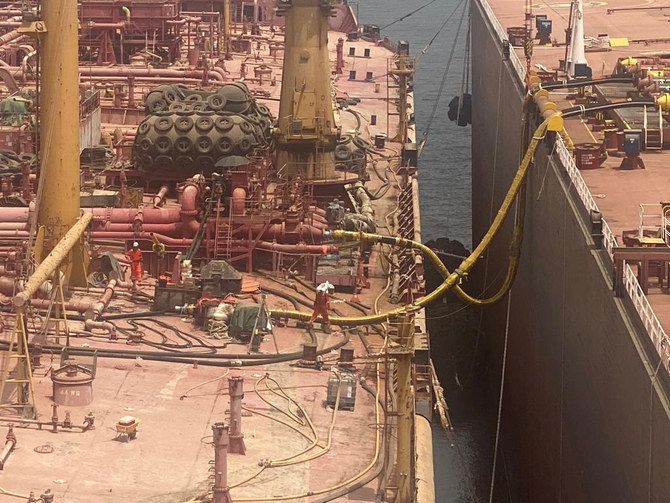 Technicians work on the deck of the replacement vessel as the transfer of oil from the decaying FSO Safer oil tanker began off Yemen July 25, 2023. (Reuters)