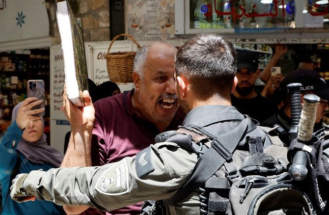 A man holds a copy of the Qur’an as Israeli police blockade the entrance to the Al-Aqsa compound, following the storming of the site by a group of settlers led by Itamar Ben-Gvir and Yitzhak Wasserlauf, Jerusalem, July 27, 2023. (Reuters)