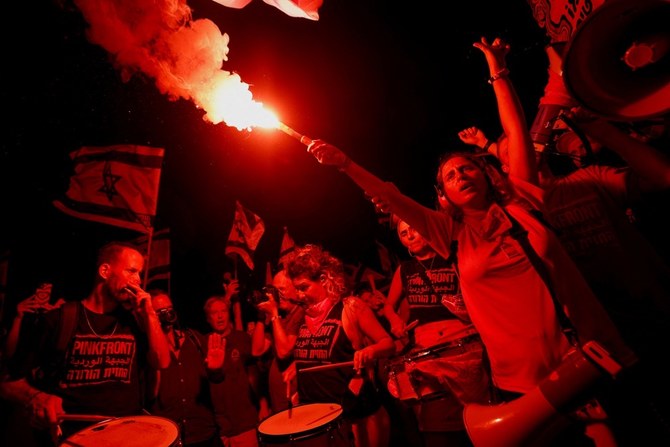 A protester holds a flare during a demonstration against Israeli Prime Minister Benjamin Netanyahu and his nationalist coalition government's judicial overhaul. (Reuters)