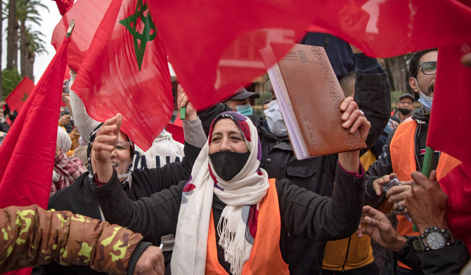 Moroccans celebrate in front of the parliament building in Rabat on December 13, 2020, after the US adopted a new official map of Morocco that includes the disputed territory of Western Sahara. (AFP)