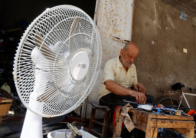 A Palestinian, Mustafa Abdou, repairs a fan in his shop amid a heatwave at the Shati refugee camp in Gaza City, July 25, 2023. (REUTERS)