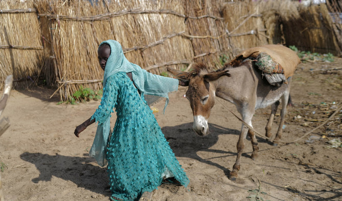 A girl displaced from Darfur pulls her donkey outside her makeshift shelter in Adre, Chad. (Reuters)