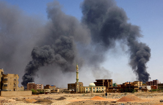 A man walks while smoke rises during clashes between the paramilitary Rapid Support Forces and the army in Khartoum. (Reuters)