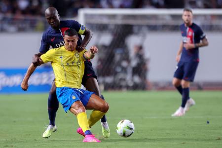 Paris Saint-Germain's Danilo Pereira (back) fights for the ball with Al-Nassr's Cristiano Ronaldo during the friendly football match at Nagai Stadium in Osaka on July 25, 2023. (AFP)