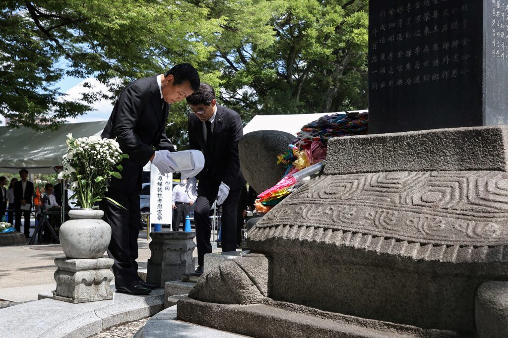 Members of Hiroshima Prefecture's regional headquarters for the Korean People's Association in Japan dedicate a list of the victims during the remembrance service on August 5. (AFP)