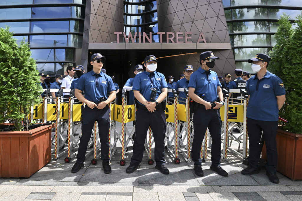 Police officers stand guard in front of a building housing the Japanese embassy in Seoul on August 24. (AFP)