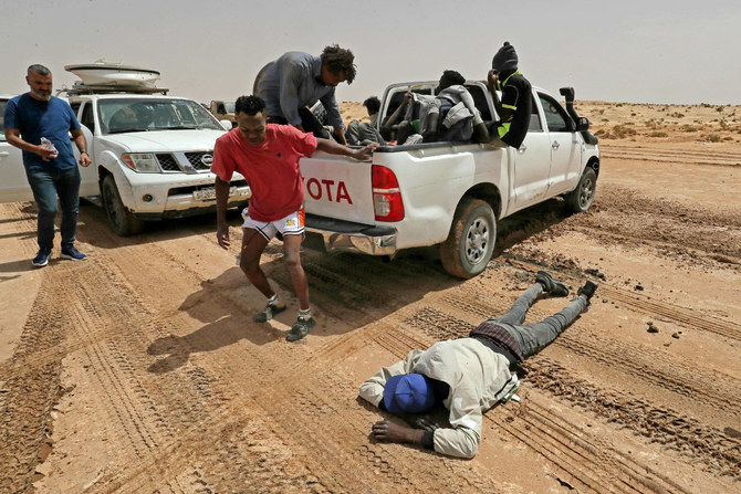 A migrant of African origin collapses due to exhaustion and dehydration upon his arrival in an uninhabited area near al-Assah on the Libya-Tunisia border on July 30, 2023. (AFP)