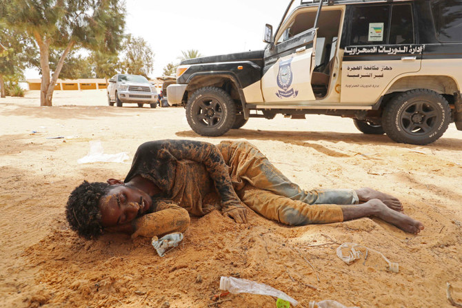 A migrant of African origin collapses upon his arrival in an uninhabited area near Al-Assah on the Libya-Tunisia border on July 30, 2023. (AFP)