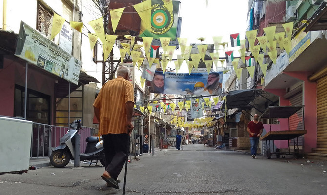 People walk past closed shops in the aftermath of clashes between the Fatah movement and Islamists inside the Ain Al-Helweh Palestinian refugee camp in the southern coastal city of Sidon on August 1, 2023. (AFP)
