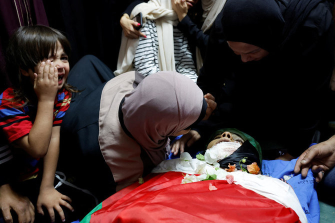 Mourners tend to the body of a Palestinian who was killed in an Israeli raid, during his funeral in Tulkarm, in the Israeli-occupied West Bank. (Reuters)