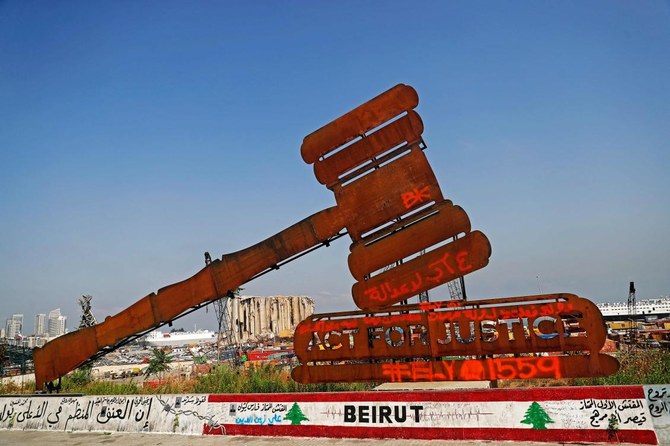 A gavel monument symbolising justice is seen in front of the damaged grain silos at Beirut’s port. Lebanon marks three years since one of history’s biggest non-nuclear explosions rocked Beirut in August 2020. (AFP)