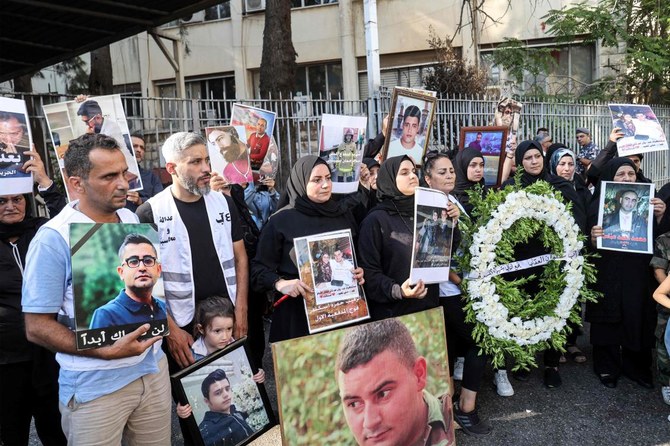 Families of the victims of the 2020 Beirut Port blast demonstrate with their portraits outside the Justice Palace in Beirut on August 4, 2023 on the third anniversary of the deadly explosion. (AFP)