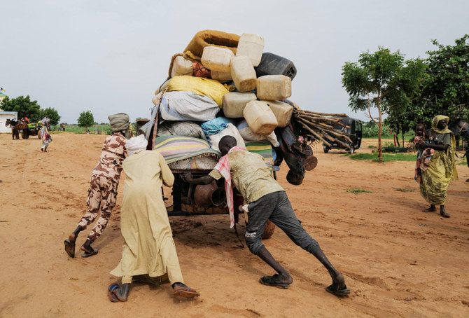 A Chadian cart owner who transports belongings of Sudanese people who fled the conflict in Sudan's Darfur region, pushes his cart while crossing the border between Sudan and Chad in Adre, Chad August 4, 2023. (REUTERS)