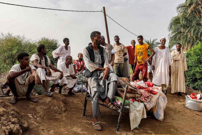 People sit outdoors on salvaged furniture in an area devastated by floods in Al-Sagai north of Omdurman on August 6, 2023. (AFP)