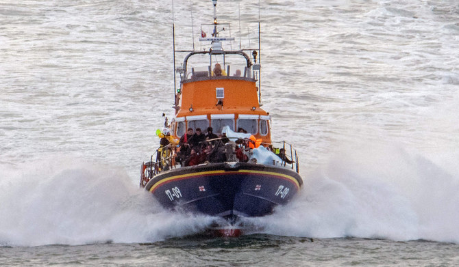 Migrants picked up at sea while attempting to cross the English Channel, are brought by a UK Royal National Lifeboat Institution (RNLI) lifeboat into the Marina in Dover, southeast England, on August 12, 2023. (AFP)