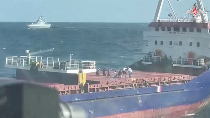 A still image from a video, released by Russia’s Defense Ministry, shows what it said to be crew members kneeling down on the deck during an operation held by Russian navy officers to board the Palau-flagged Sukru Okan vessel with the help of a Ka-29 military helicopter in the Black Sea on August 13, 2023. (Reuters via Russian Defense Ministry)
