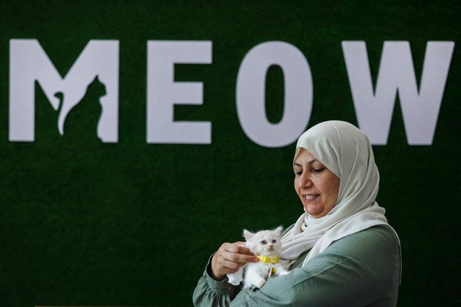 Owner Nehma Maabad holds a feline at her newly inaugurated Cat Cafe in Gaza City. (AFP)