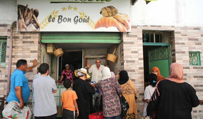People queue in front of a bakery in Tunis on Saturday. Authorities are reinstating subsidized flour supply to more than 1,000 privately-owned bakeries. (AFP)