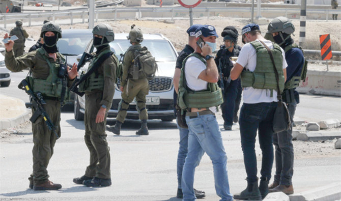 Israeli security forces block a road leading to the site of a reported attack south of Hebron in the occupied West Bank on Monday. (AFP)