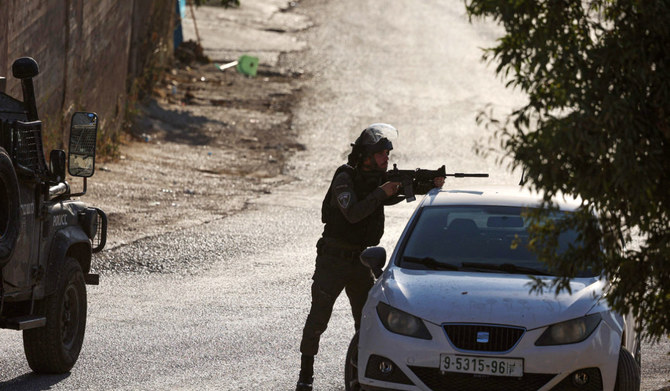 An Israeli soldier aims a weapon during a search operation in the Palestinian village of Baita in the occupied West Bank, on August 21, 2023. (AFP)