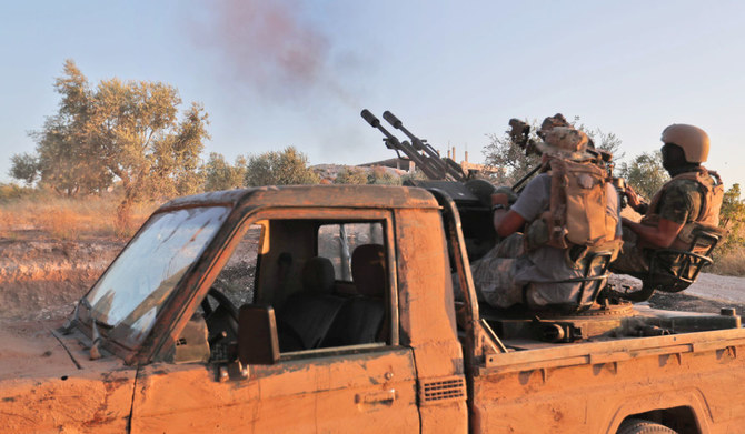 A fighter from the former al-Qaeda Syrian affiliate Hayat Tahrir al-Sham (HTS) fires an anti-aircraft gun mounted on a pickup truck in Syria's southern Idlib province. (AFP file photo)