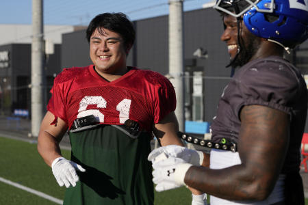 Hidetora Hanada (left), a former amateur sumo wrestling champion, shares a light moment with Christian Onyechi, an IBM Big Blue member, as they work out in Chiba, east of Tokyo, Japan, on July 29, 2023. (AP)