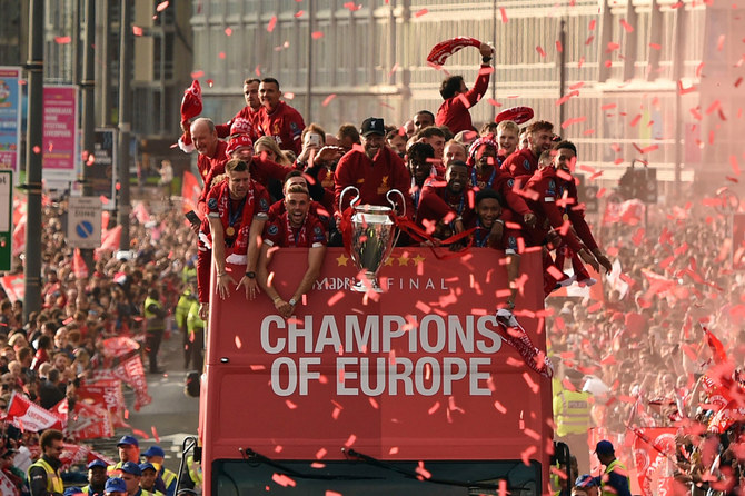 Liverpool's German manager Jurgen Klopp (C) holds the European Champion Clubs' Cup trophy during an open-top bus parade around Liverpool in 2019. (File/AFP)
