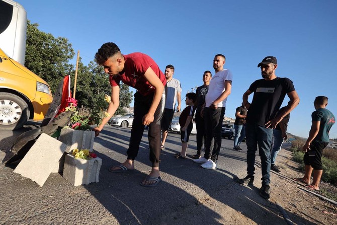 Mourners lay roses at the site where three Palestinians where killed by Israeli forces near the Jenin camp, north of the occupied West Bank, on August 6, 2023. (AFP)