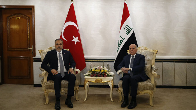 Iraq's Foreign Minister Fuad Hussein (R) poses with Turkey's Foreign Minister Hakan Fidan in Baghdad. (AFP)