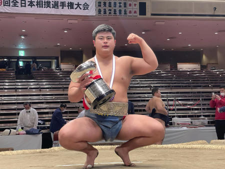 Hidetora Hanada poses for a photo as he celebrates with his trophy after winning an amateur sumo wrestling national competition, in Tokyo, Japan, on Dec. 6, 2020. (AP)