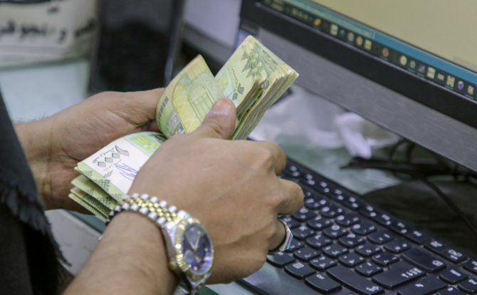 A cashier counts Yemeni riyal banknotes at a local currency exchange in Aden, Yemen. (File/Reuters)