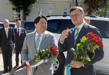 Ukraine's Foreign Minister Dmytro Kuleba and his Japanese counterpart Yoshimasa Hayashi visit the Memory Wall of Fallen Defenders of Ukraine in Kyiv, Ukraine, on Saturday. (Reuters)