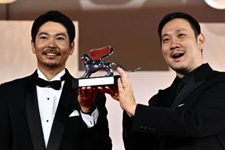 Japanese director Ryusuke Hamaguchi (right) poses with actor Hitoshi Omika after receiving the Silver Lion - Grand Jury Prize at the 80th Venice Film Festival on September 9, 2023 at Venice Lido. (AFP)