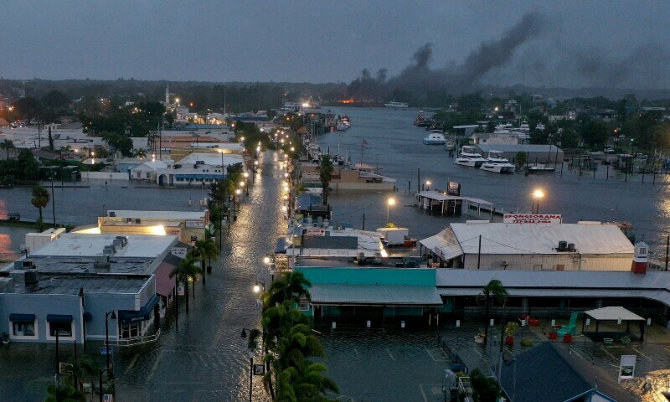 A fire is seen as flood waters inundate the downtown area after Hurricane Idalia passed offshore on August 30 in Tarpon Springs, Florida, US. (AFP)