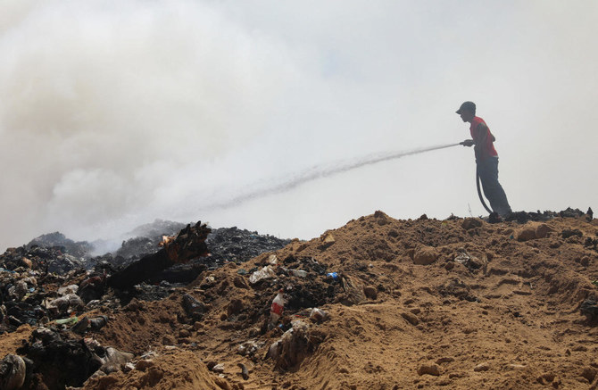 A Palestinian extinguishes a fire at a landfill in Juhr al-Deek, southeast of Gaza City, September 3, 2023. (Reuters)