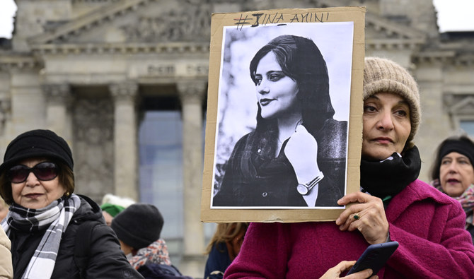 A woman holds a portrait of Mahsa Amini during a demonstration in front of the German lower house of parliament (Bundestag), on the occasion of the International Women's Day, on March 8, 2023. (AFP/File)