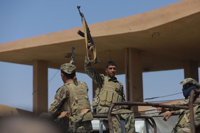 Fighters of the Syrian Democratic Forces (SDF) gesture as they move from Deir Ezzor to the Dhiban front line in eastern Syria (AFP)