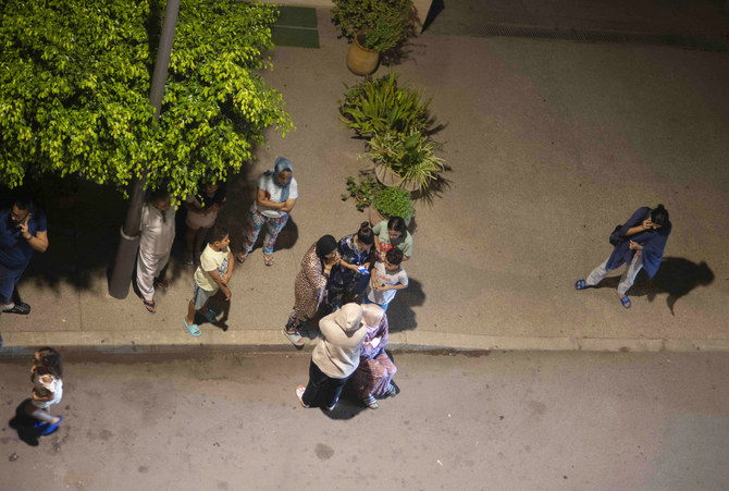 People take shelter and check for news on their mobile phones after an earthquake in Rabat, Morocco, late Friday, Sept. 8, 2023. (AP)