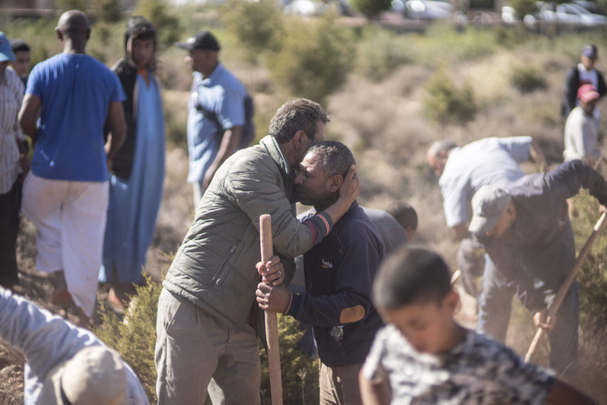 People comfort each other while digging graves for victims of the earthquake, in Ouargane village, near Marrakech, Morocco, Saturday, Sept. 9, 2023. (AP)