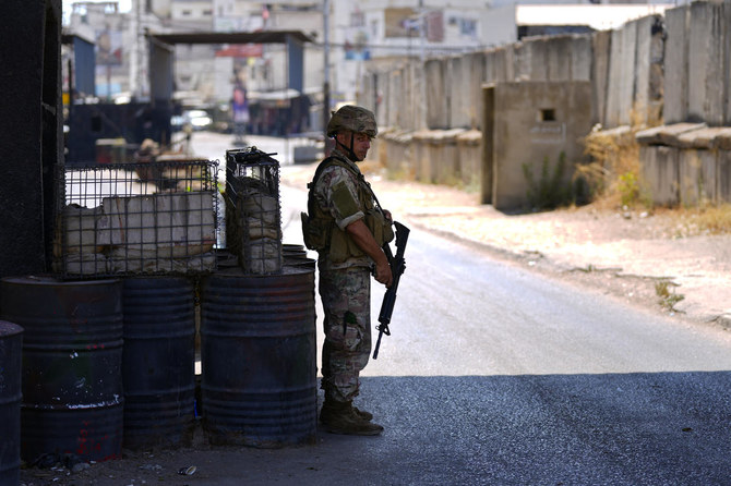 A Lebanese army soldier stands guards at the entrance of Palestinian refugee camp of Ein el-Hilweh during clashes between members of the Palestinian Fatah group and Islamist militants near the southern port city of Sidon, Lebanon, Sunday, Sept. 10, 2023. (AP)