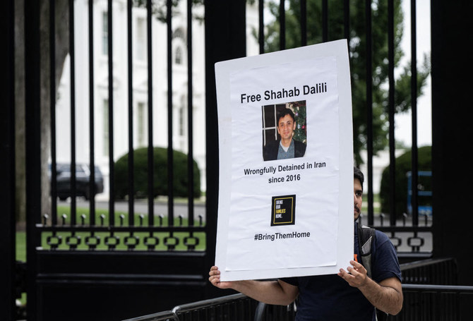 Darian Dalili holds up a sign as he protests during a hunger strike outside the White House in Washington, DC on August 14, 2023. (AFP)