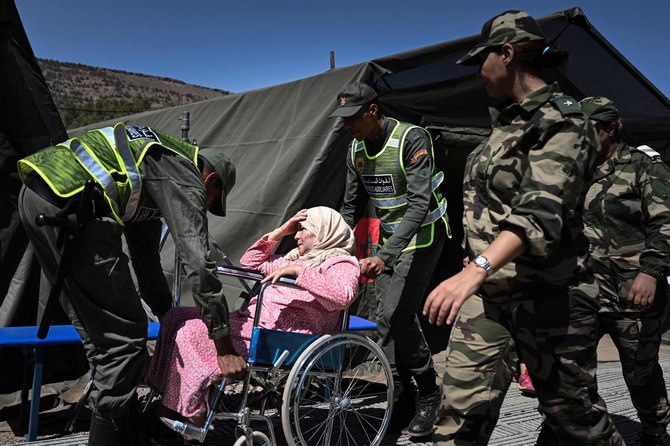 Morocco's auxiliary forces attend to a woman in a wheelchair at a military field hospital erected to assist survivors of the September 8 earthquake. (File/AFP)