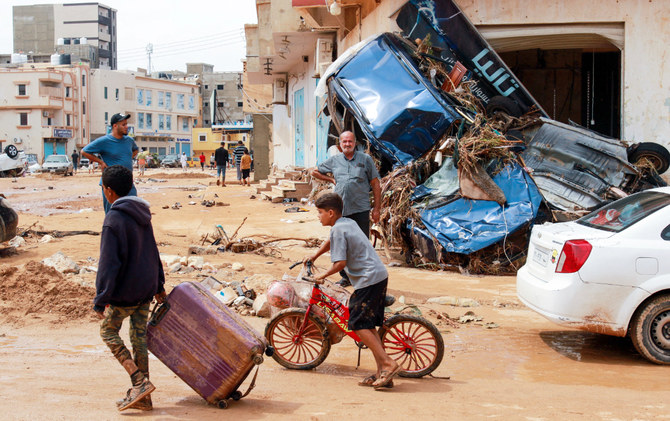 A boy pulls a suitcase past debris in a flash-flood damaged area in Derna, eastern Libya, on September 11, 2023. (AFP)