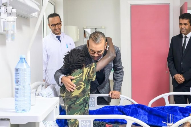 Morocco’s King Mohamed VI embraces an African migrant earthquake victim during his visit to Mohamed V hospital in Marrakech Tuesday evening. (EXCLUSIVE IMAGE/ROYAL PALACE)