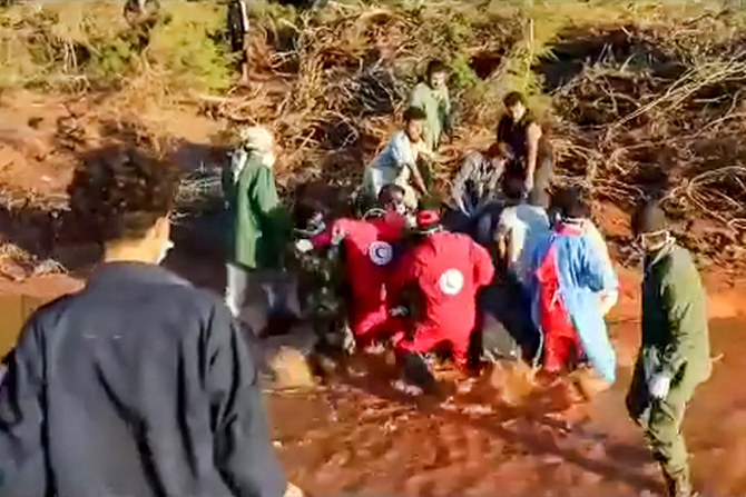 This image grab from handout video released by the Libyan Red Crescent on September 13, 2023 shows volunteers carrying a body bag during search operations after deadly floods in the east of the country. (The Libyan Red Crescent via AFP)