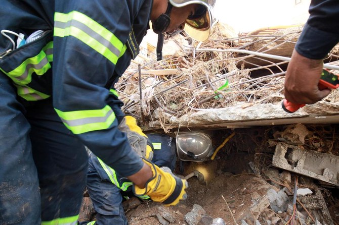 Fire and rescue brigades search for survivors through the rubble of a building that collapsed during floods after the Mediterranean storm