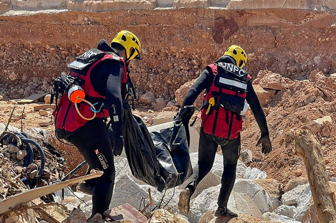 A handout picture provided by Tunisia's National Office of Civil Protection on September 15, 2023, shows members of its emergency teams recovering a body while assisting in relief work in Libya's city of Derna in the aftermath of a devastating earthquake. (AFP)