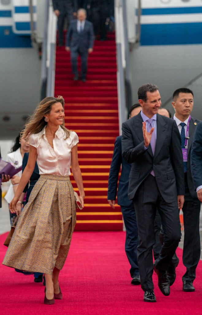A handout picture released by the official Syrian Arab News Agency shows Syria's President Bashar Assad (C) and wife Asma being welcomed upon their arrival at Hangzhou airport in Beijing, China, on September 21, 2023. (SANA via AFP)