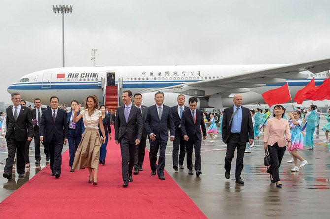 A handout picture released by the official Syrian Arab News Agency shows Syria's President Bashar Assad (C) and wife Asma arriving at Hangzhou airport in Beijing, China, on September 21, 2023. (SANA via AFP)